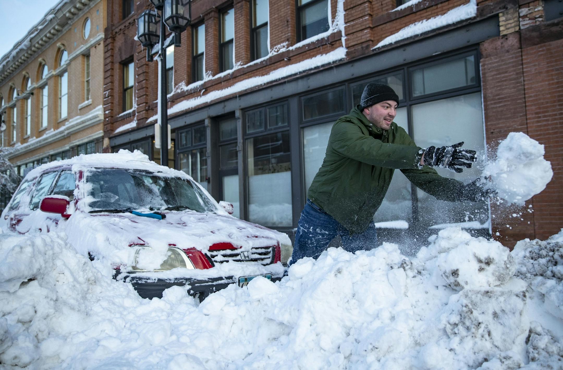Alex Stock attempted to dig his car out of a snowbank by hand on First St. in Duluth, MN on Sunday afternoon. He eventually freed his car.