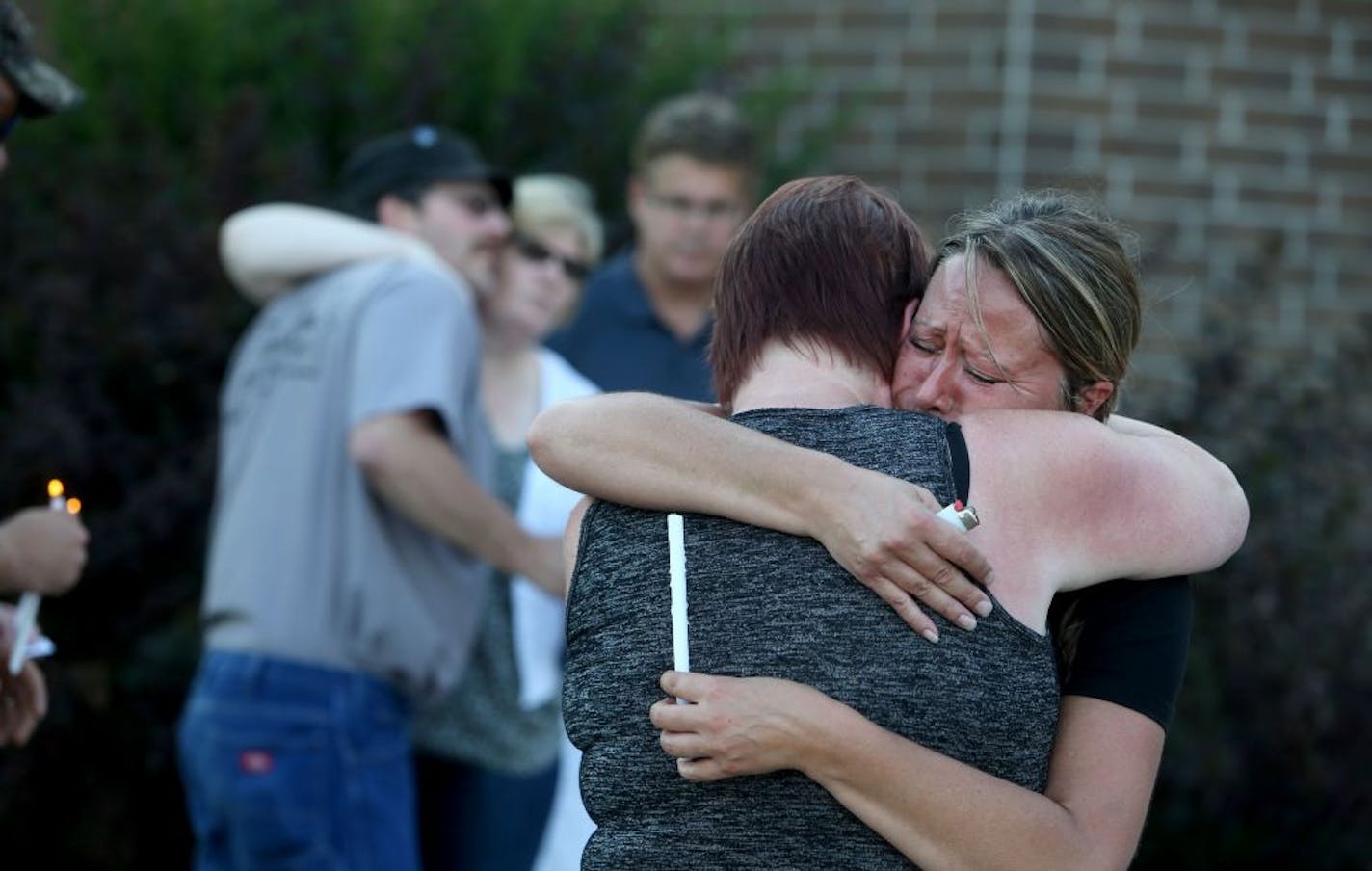 U.S. Marine Carson Holmquist had deep ties to Grantsburg, Wis., where he graduated from high school in 2008 before joining the military. Holmquist was among four U.S. Marines killed during an attack in Chattanooga, TN, Thursday. Here, Sue Holmquist, back to the camera, Carson's stepmother, is hugged by an unidentified person during a vigil Friday, July 17, 2015, for Holmquist outside Grantsburg WI High School, where Holmquist from graduated in 2008. Tom Holmquist, Carson's father, is at the rear