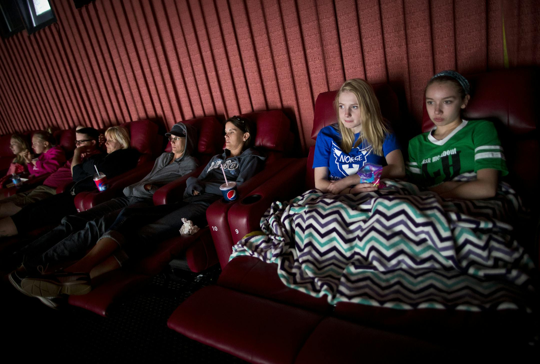 Mara Lindquist, 18, and Abby Persoon (CQ) (in green) cuddled under a blanket as relaxed in recliner chairs at a movie on Wednesday, June 17, 2014, at Marcus Theater in Oakdale, Minn. The new recliners in several theaters in the Twin Cities are part of the way that owners are attracting people back to the theater, along with restaurant quality food, alcohol, self-serve snacks and drinks and of course, better sounds and bigger screens. An upgrade from seats that just rock, the leather recliner lea