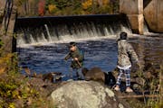 Siblings Silus, 6, left, and Meverick Yang, 10, fished from the Hinckley Dam on the Grindstone River in Hinckley, Minn., on Tuesday. They were there w