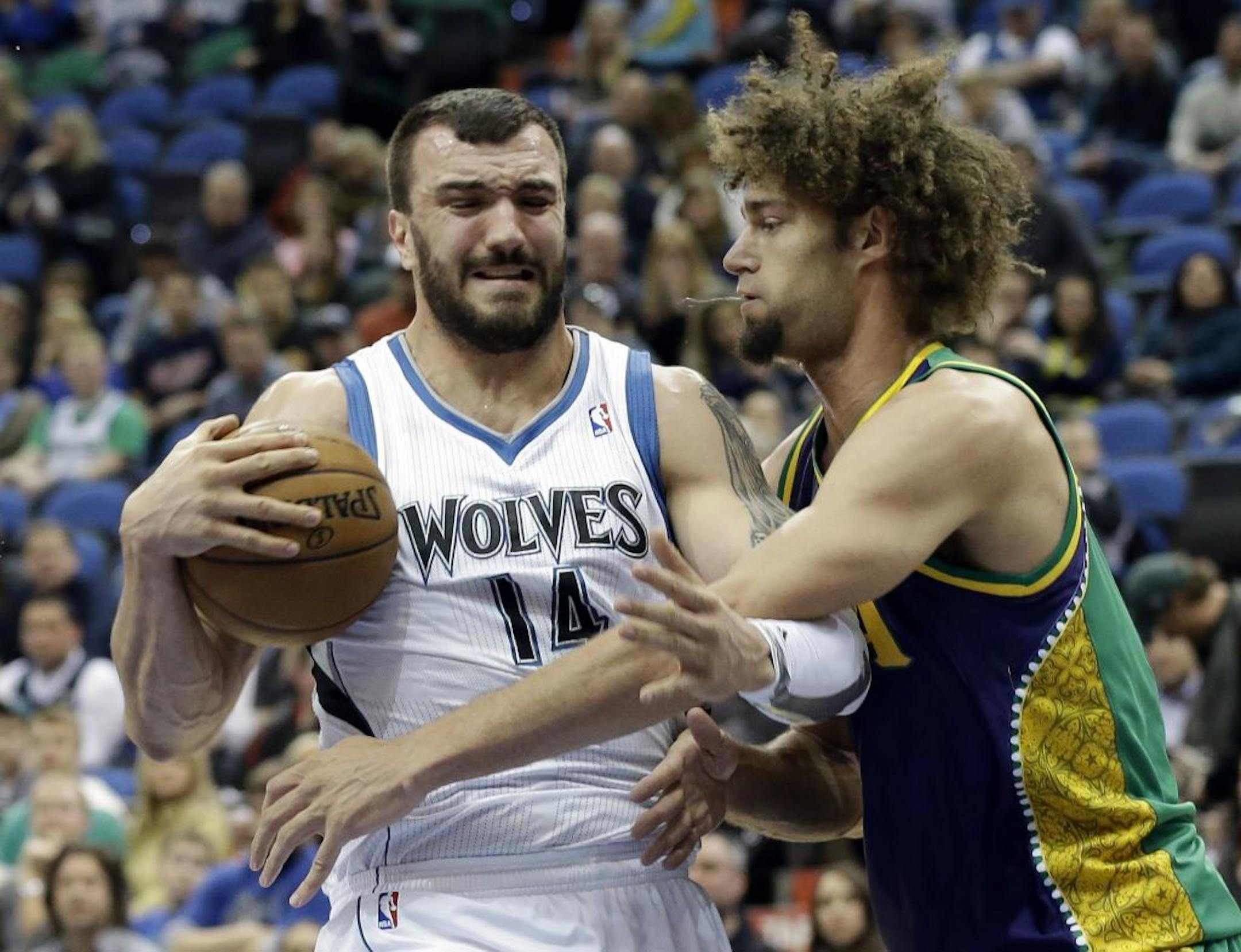 Minnesota Timberwolves' Nikola Pekovic of Montenegro, left, protects the ball from New Orleans Hornets defender Robin Lopez in the first quarter of an NBA basketball game Saturday, Feb. 2, 2013 in Minneapolis.