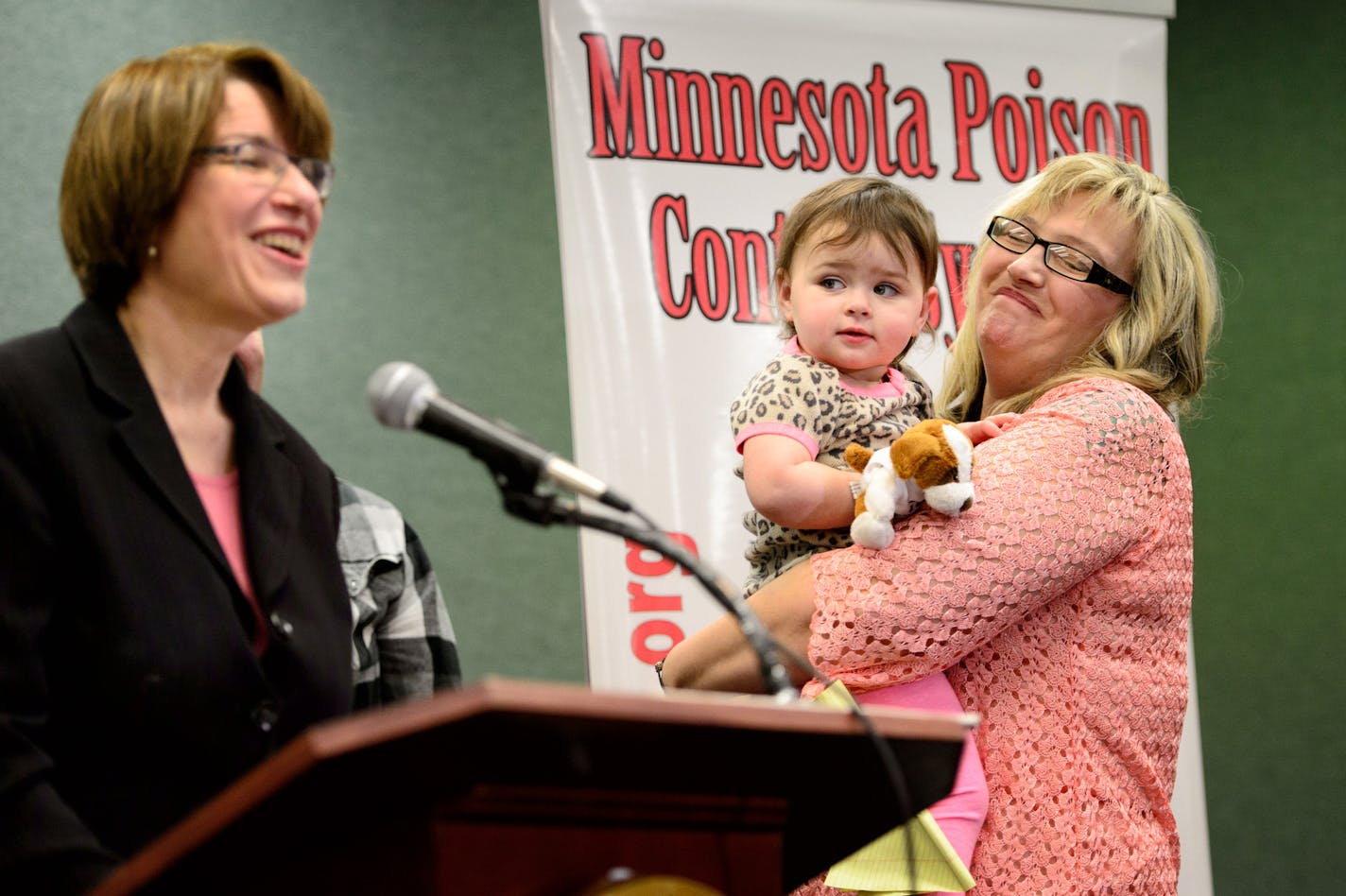 Zoey Mishler, 21 months, and her grandmother Shelly Olson looked on as U.S. Senator Amy Klobuchar announced efforts to set safety standards for liquid detergent packets. Zoey received near-fatal chemical burns in her mouth and down her throat after eating one of the detergent packs last year. ] GLEN STUBBE * gstubbe@startribune.com Friday, April 10, 2015 At the Minnesota Poison Control System at HCMC, U.S. Senator Amy Klobuchar announced efforts to set safety standards for liquid detergent packe