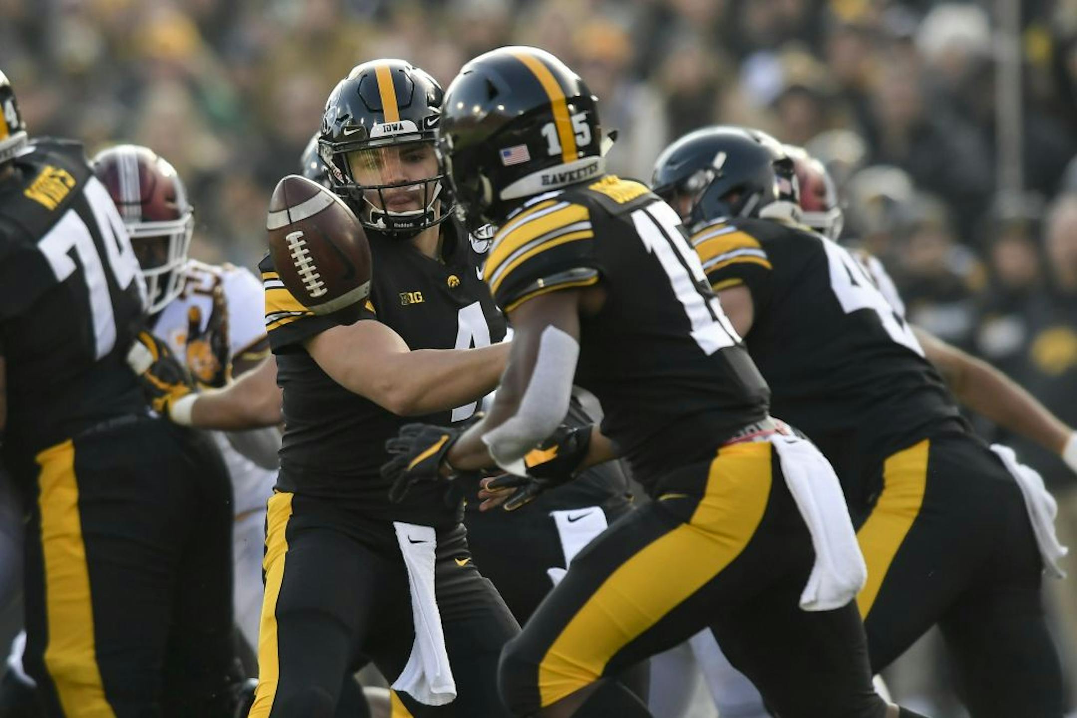 Iowa Hawkeyes quarterback Nate Stanley (4) tossed the ball to running back Tyler Goodson (15) who ran it for a first down against the Minnesota Gophers in the first quarter.