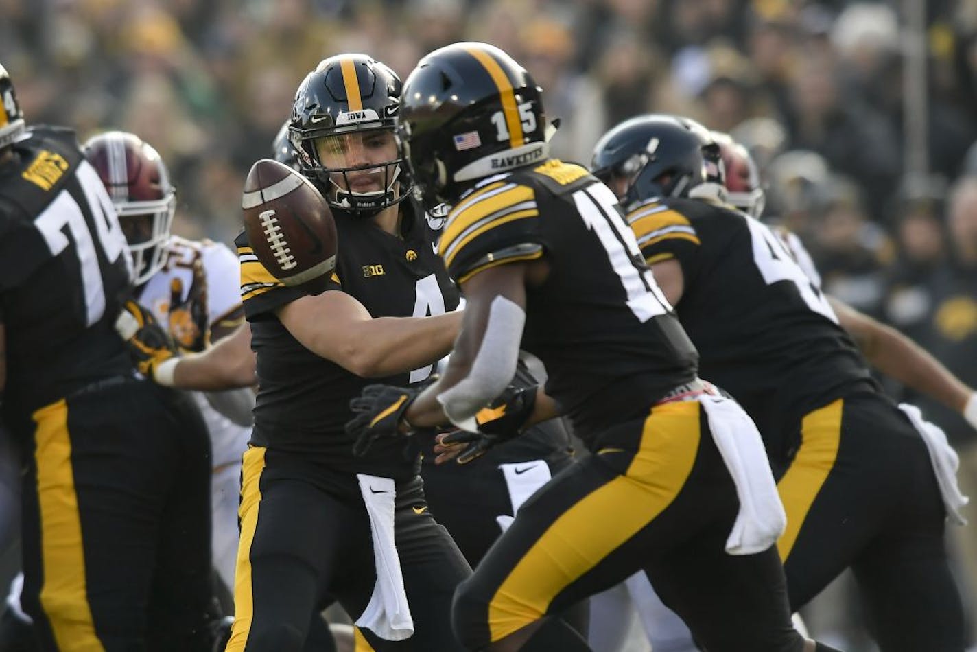 Iowa Hawkeyes quarterback Nate Stanley (4) tossed the ball to running back Tyler Goodson (15) who ran it for a first down against the Minnesota Gophers in the first quarter.