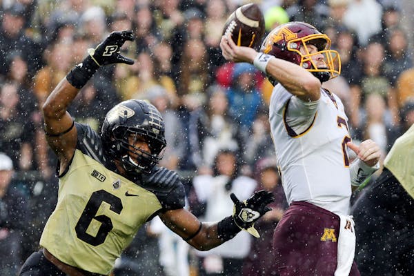 Gophers quarterback Tanner Morgan got off a pass as Purdue linebacker Jalen Graham moved in on him in the second half Saturday.
