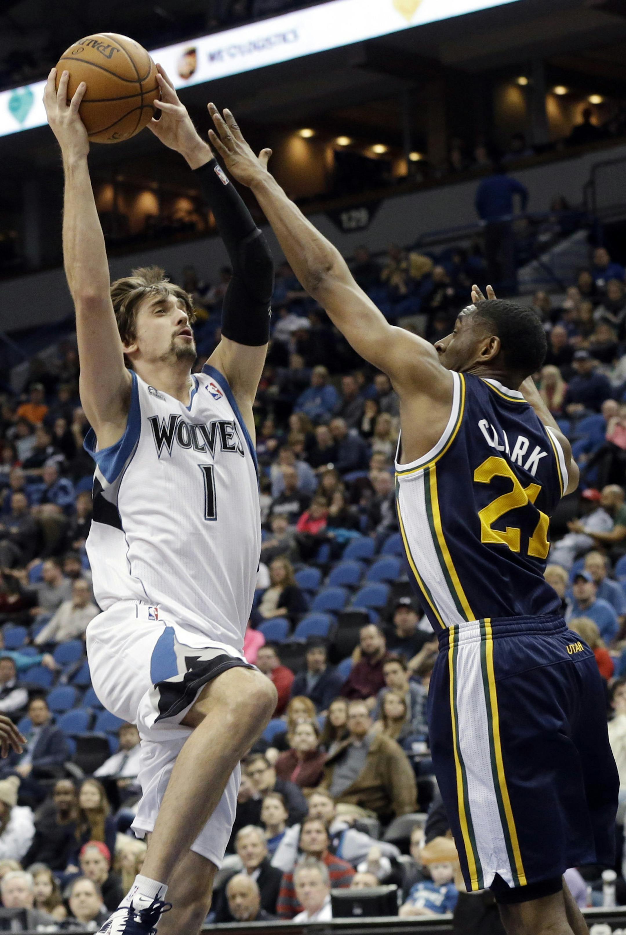 Minnesota Timberwolves' Alexey Shved, left, of Russia, shoots over Utah Jazz's Ian Clark during the second half of an NBA basketball game, Saturday, Jan. 18, 2014, in Minneapolis. The Timberwolves won 98-72. (AP Photo/Jim Mone) ORG XMIT: MIN2014012018553373