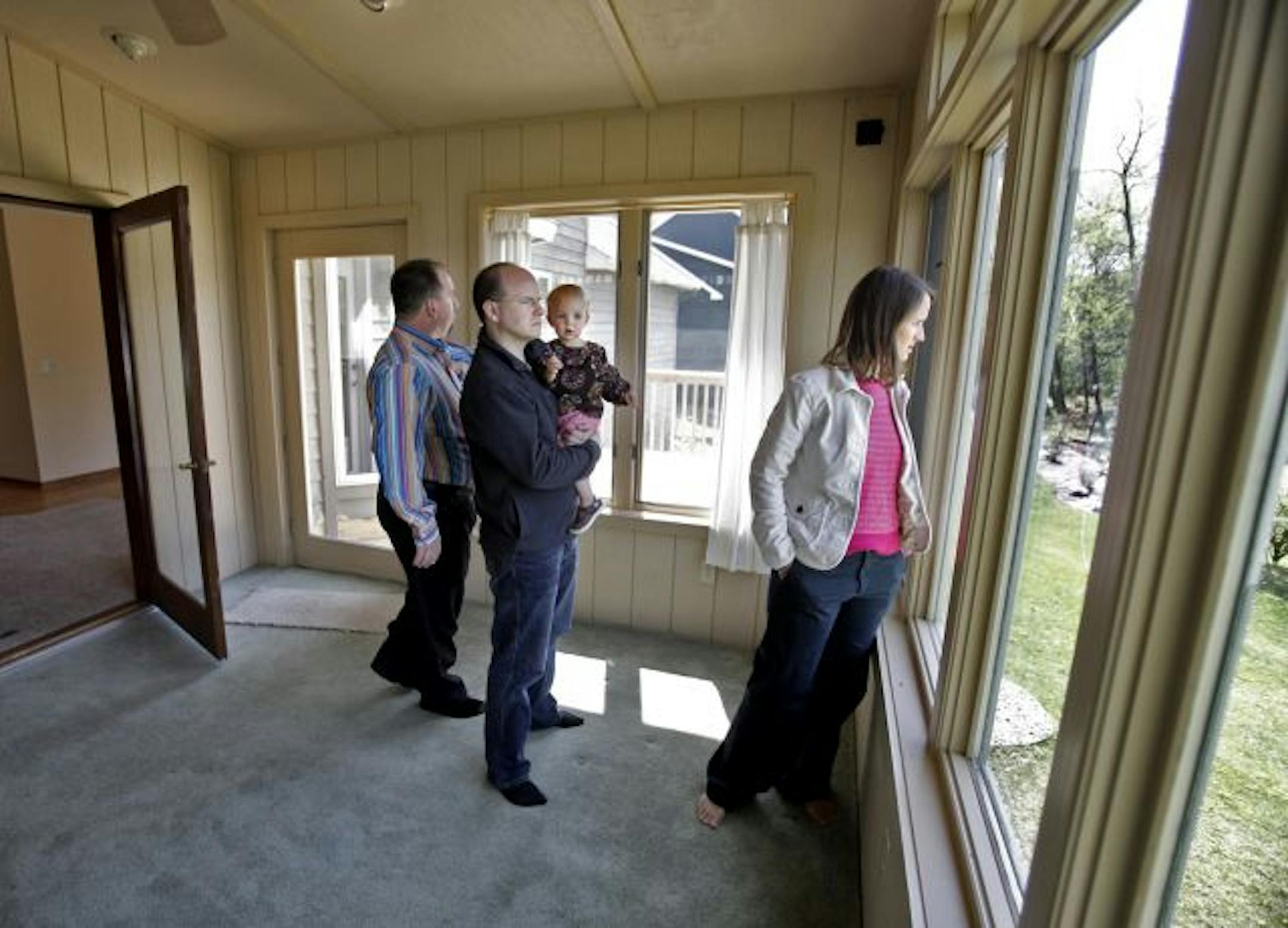 With just three days to go until the tax credit ends, Bethany and Tony Kelleran have revved up their house hunting. Here, Tony held their 19-month-old daughter Hayden and checked the back yard of a foreclosed home in Eden Prairie with Bethany and Realtor Jim Starr.