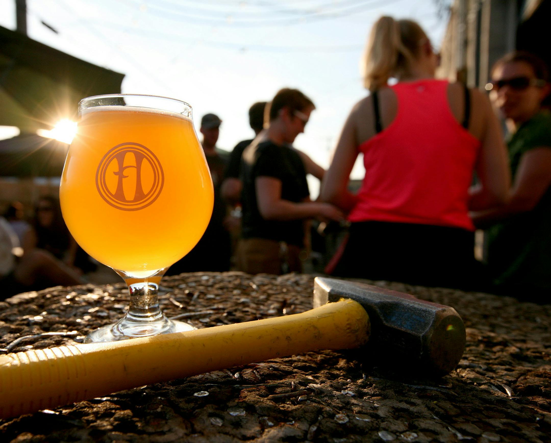 A glass of Saison Nourrice, traditionally brewed for farmhands during hot summer months, sits on a Hammerschlagen stump that doubles as a patio table at Harriet Brewing in Minneapolis June 29, 2013. (Courtney Perry/Special to the Star Tribune) ORG XMIT: MIN1307011120210640