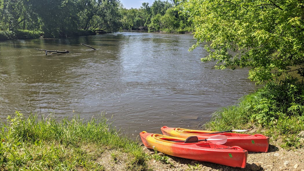 Two rental kayaks waited on the shore of the Cannon River near Faribault, Minn.