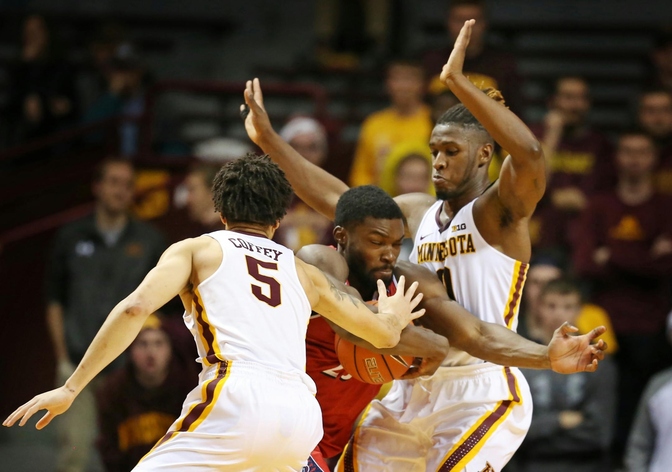 N.J.I.T Highlanders guard Rob Ukawuba (25) drove the lane on Minnesota Golden Gophers guard Akeem Springs (0) , and guard Amir Coffey (5)at Williams Arena December 06,2016 in Minneapolis , MN.