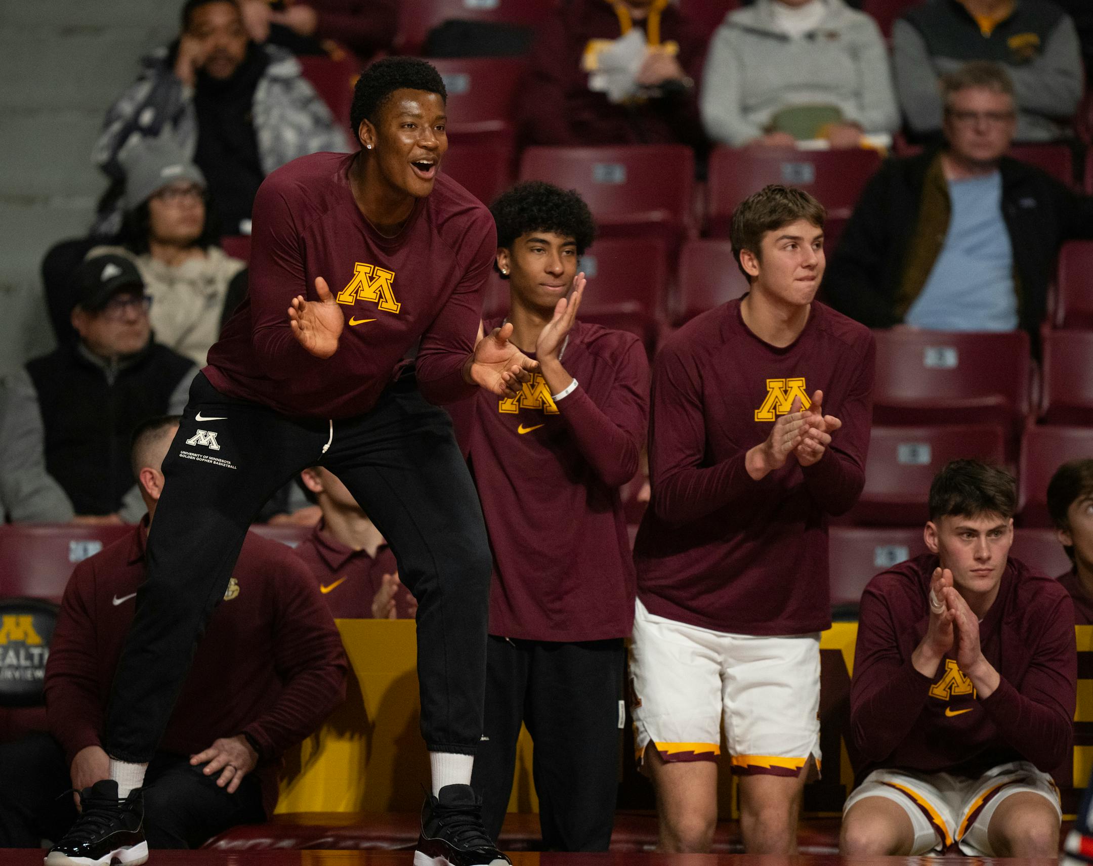 Minnesota Gophers forward Pharrel Payne, and guard Cam Christie cheered their teammates from the bench in the second half, along with Erick Reader, and Will Ramberg, from left.