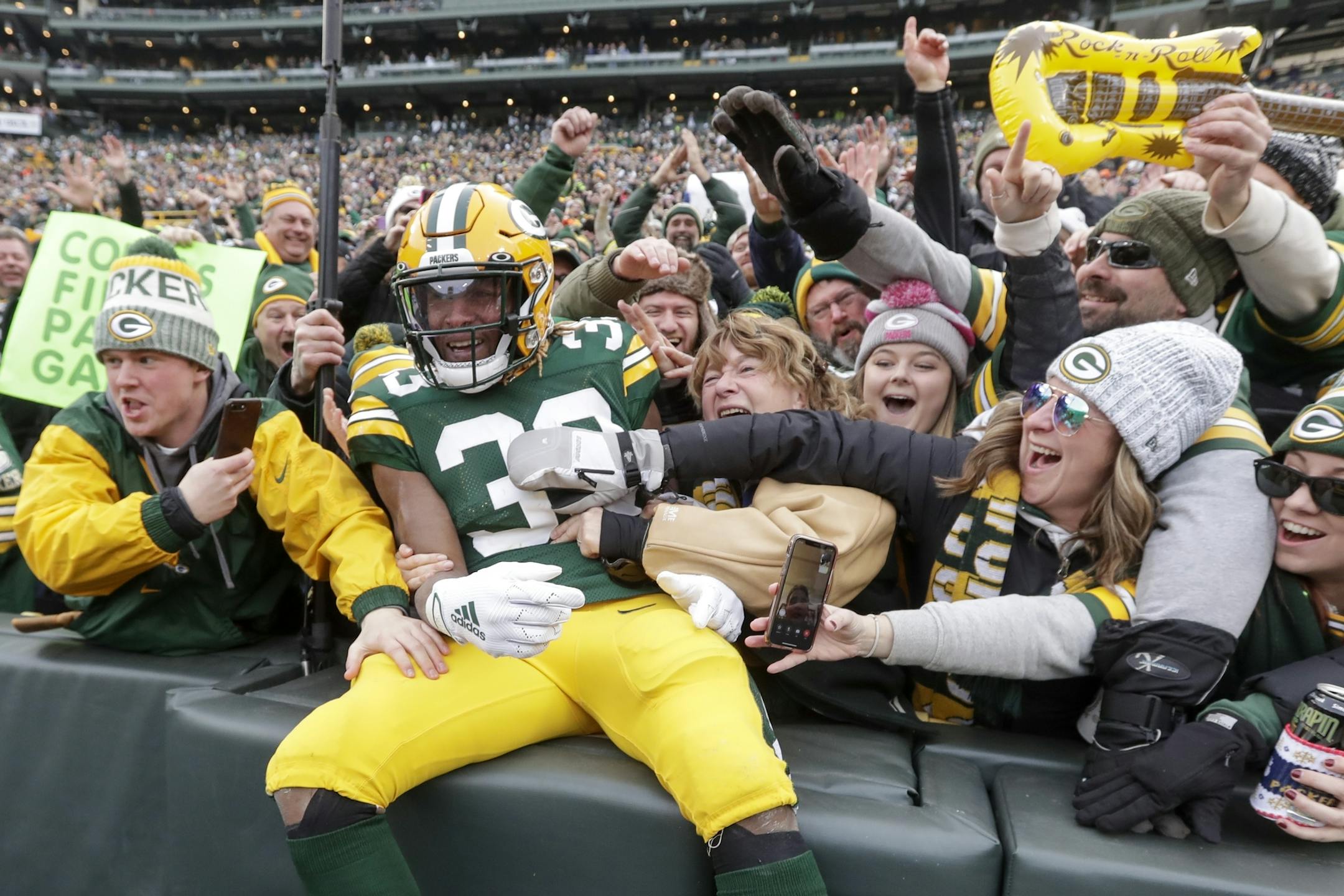 Green Bay Packers' Aaron Jones celebrates with fans after running for a touchdown during the first half of an NFL football game against the Washington Redskins Sunday, Dec. 8, 2019, in Green Bay, Wis. (AP Photo/Morry Gash)