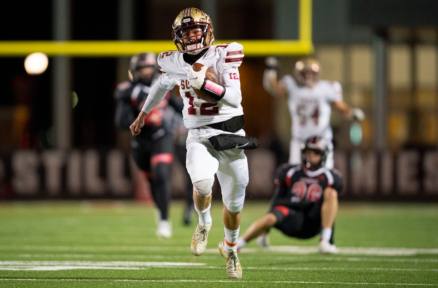 Lakeville South High School quarterback Camden Dean (12) breaks out for a long rushing touchdown against Shakopee High School in the first quarter in a 6A football quarterfinals game Friday, Nov. 12, 2021 in Stillwater, Minn.. Lakeville South went on to defeat Shakopee 42-28. ]