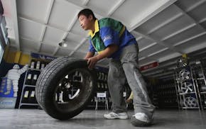 A Chinese worker rolls a tire at a tire market in Beijing, China, Wednesday, Sept. 16, 2009. China is calling for talks with Washington in the World T