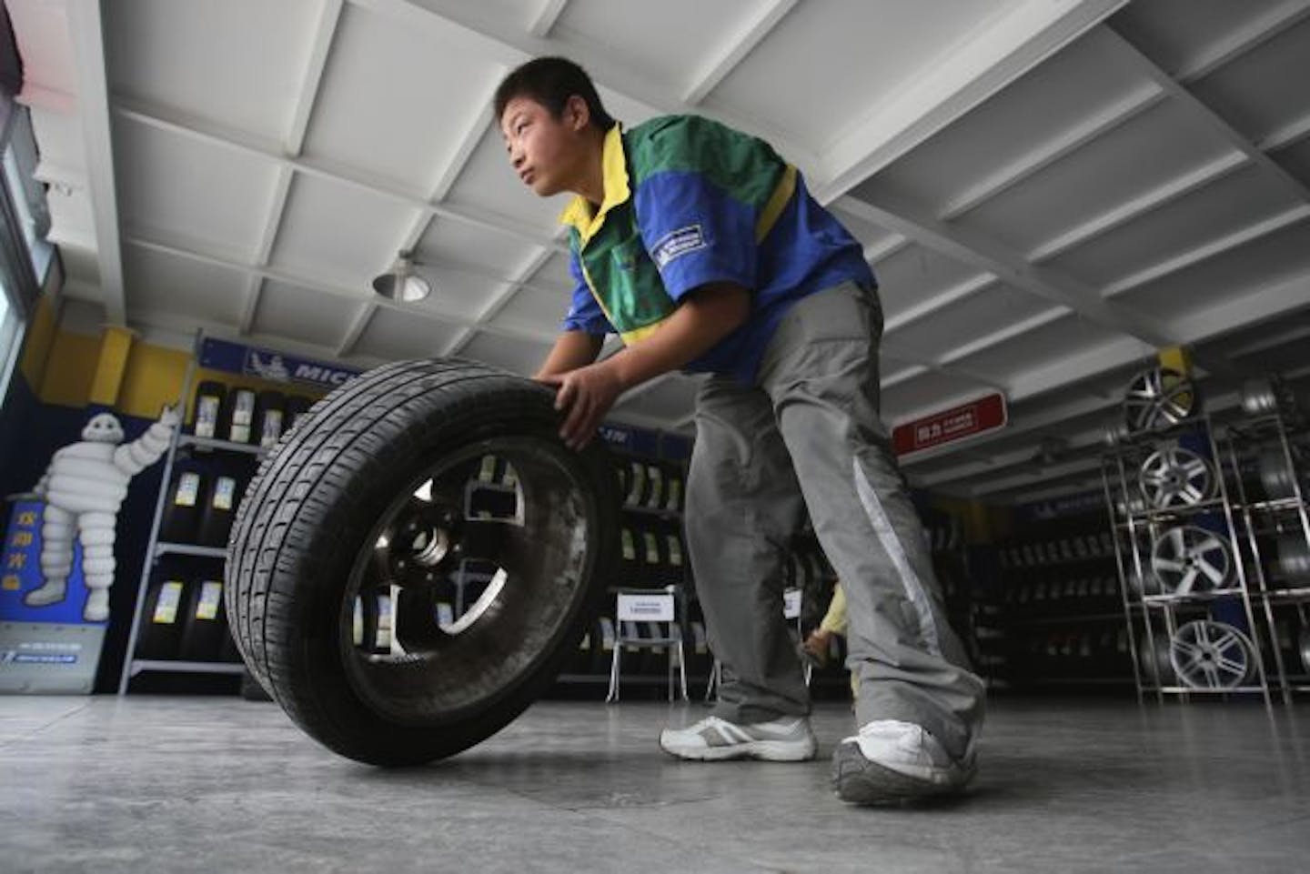 A Chinese worker rolls a tire at a tire market in Beijing, China, Wednesday, Sept. 16, 2009. China is calling for talks with Washington in the World Trade Organization over newly imposed U.S. tariffs on Chinese made tires. The Chinese government criticized the tariffs earlier as trade protectionism. The tariffs were imposed after a labor complained to Washington that surging imports of Chinese tires were wiping out American jobs.