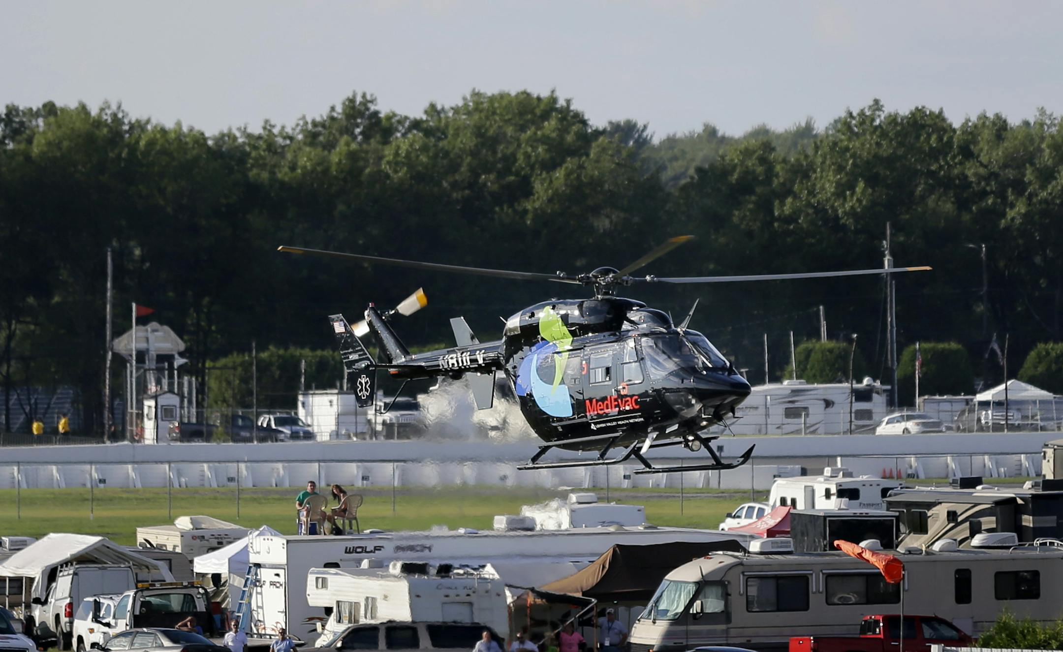 A helicopter lifts off at Pocono Raceway carrying race car driver Justin Wilson, of England, after he was involved in a crash during the Pocono IndyCar 500 auto race Sunday, Aug. 23, 2015, in Long Pond, Pa. (AP Photo/Mel Evans)