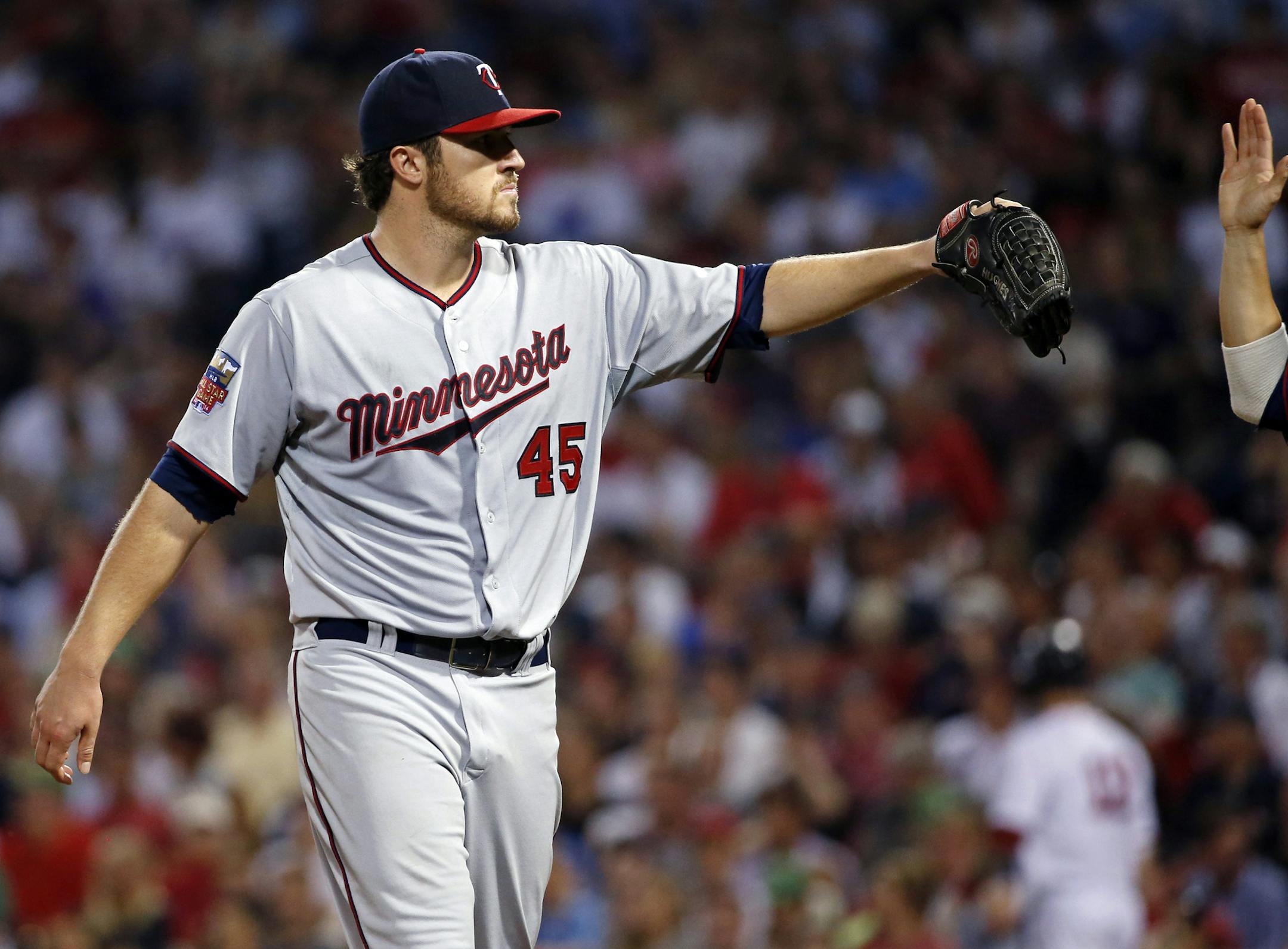 Minnesota Twins starting pitcher Phil Hughes receives a high-five as he enters the dugout after pitching the eighth inning against the Boston Red Sox in a baseball game at Fenway Park in Boston, Tuesday, June 17, 2014. The Red Sox won 2-1. (AP Photo/Elise Amendola)