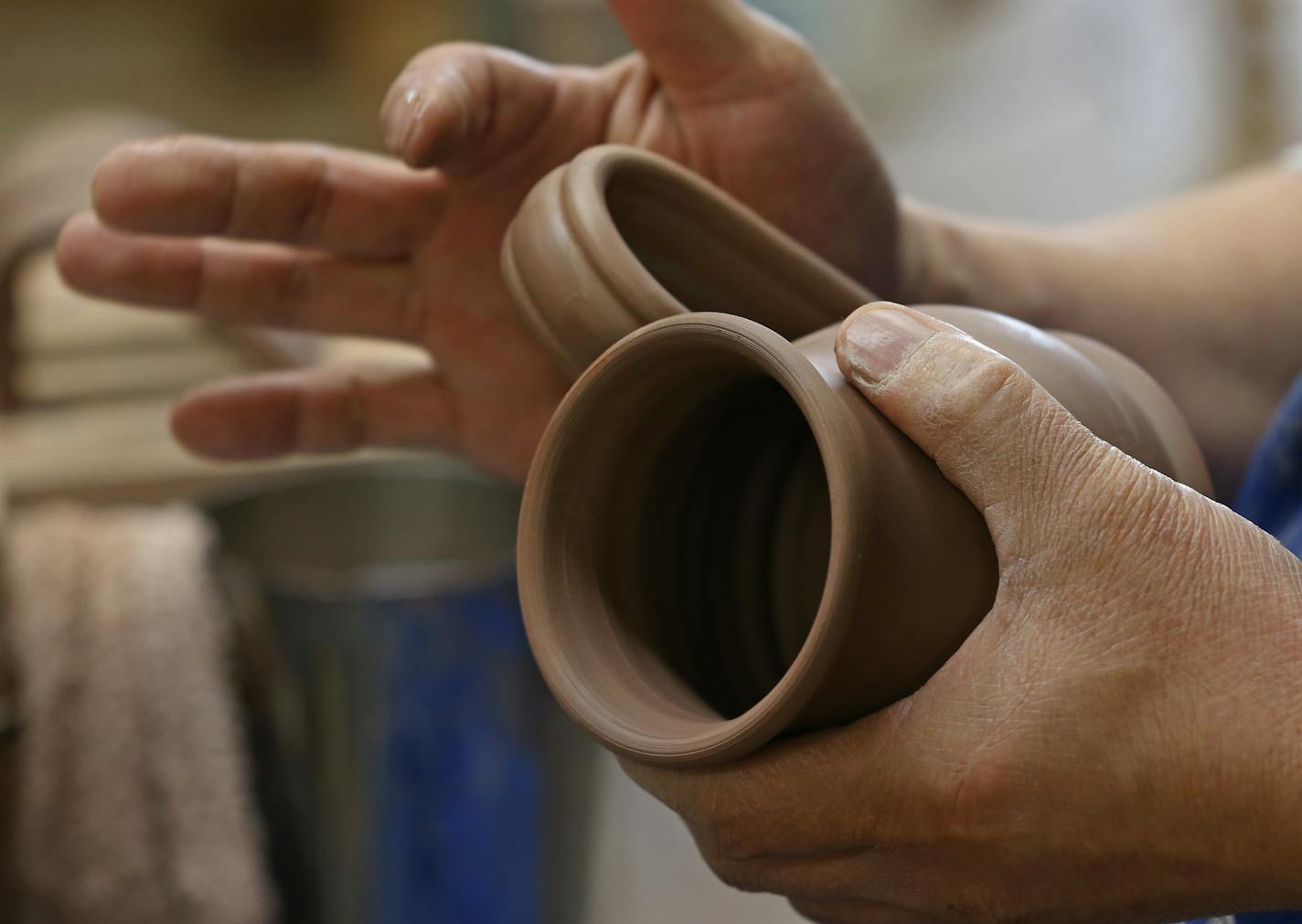 Deneen Pottery employee Jin Thao attached mug handles on 4/30/14.