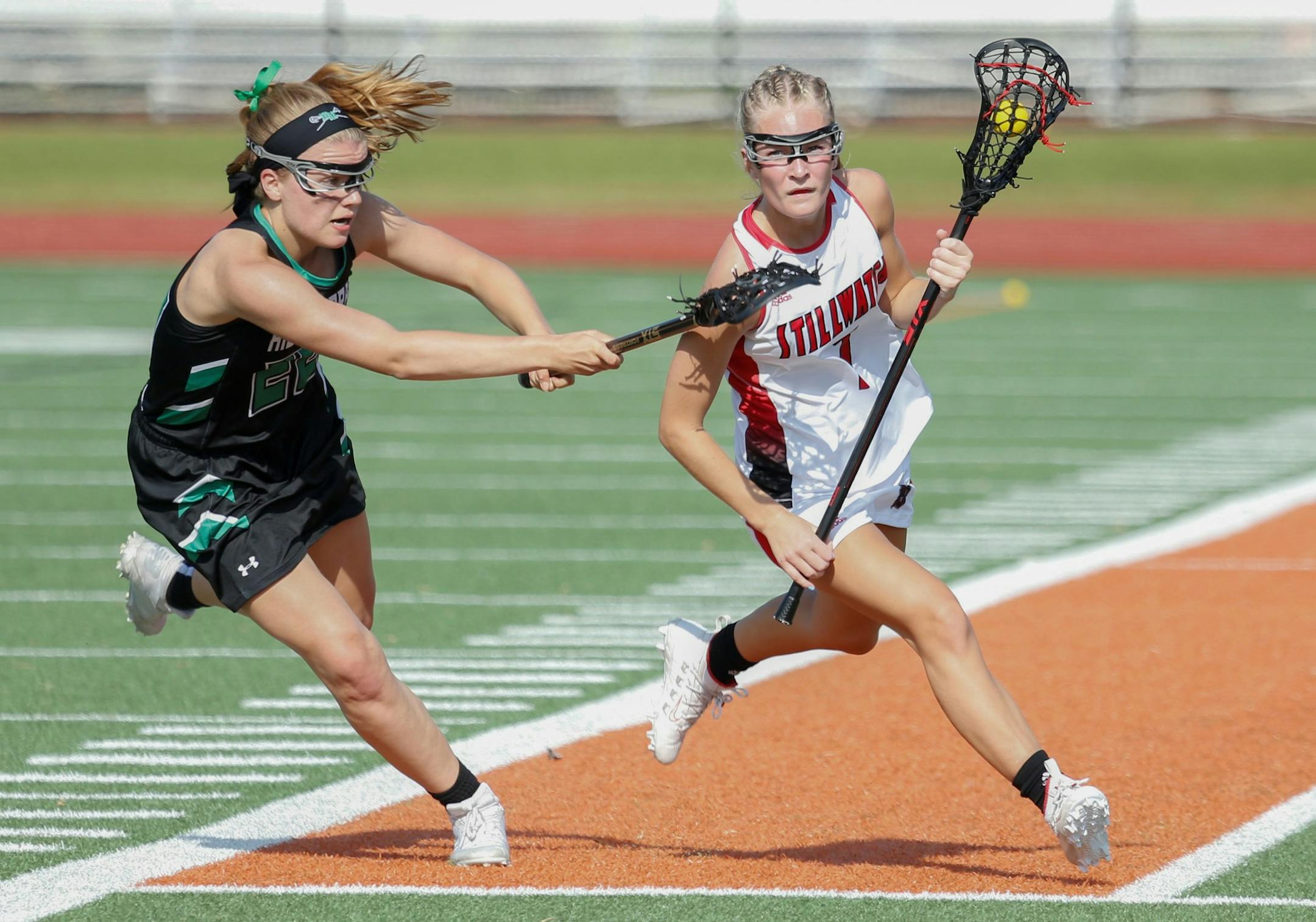Stillwater's Lauren Einan feels defensive pressure from Hill-Murray's Mia Jutz during the Section 4 Championship game Wednesday night. The Ponies defeated the Pioneers 13-8.
Photo by Jeff Lawler, SportsEngine