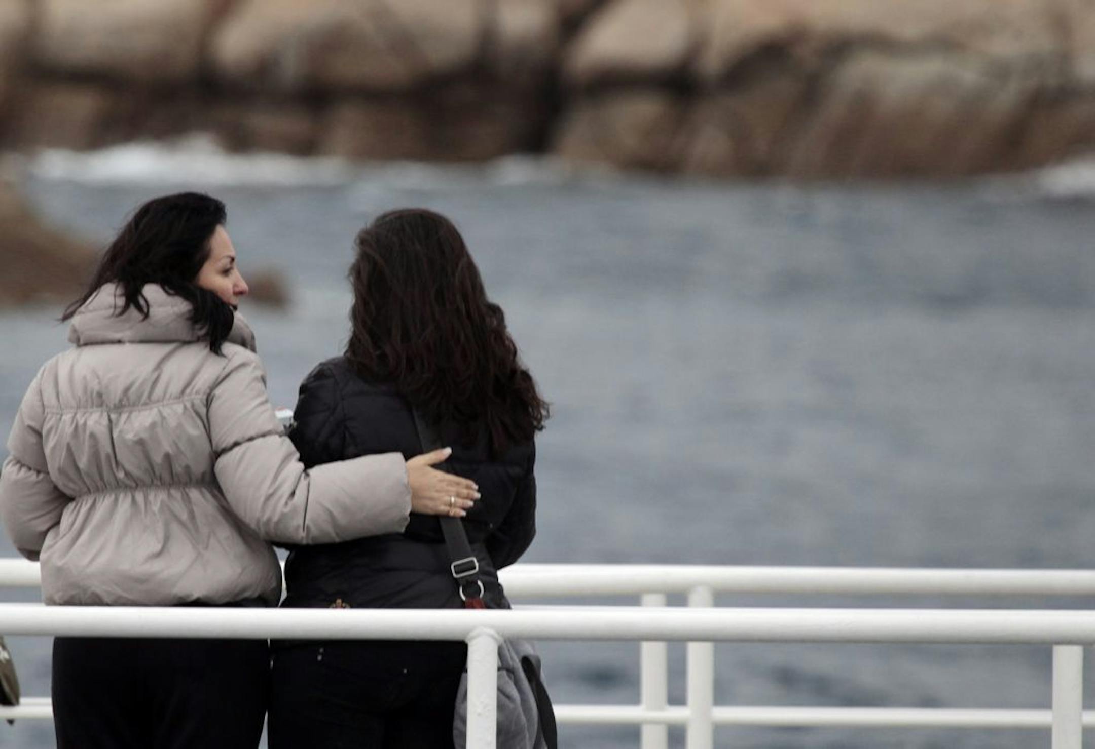 Relatives of the 32 victims of the Costa Concordia shipwreck, aboard a ferry approach the ship off the Tuscan Island Isola del Giglio, Italy, Sunday, Jan. 13, 2013. Survivors of the Costa Concordia shipwreck and relatives of the 32 people who died marked the first anniversary of the grounding Sunday. The first event of Sunday's daylong commemoration was the return to the sea of part of the massive rock that tore into the hull of the 112,000-ton ocean liner on Jan. 13, 2012 and remained embedded