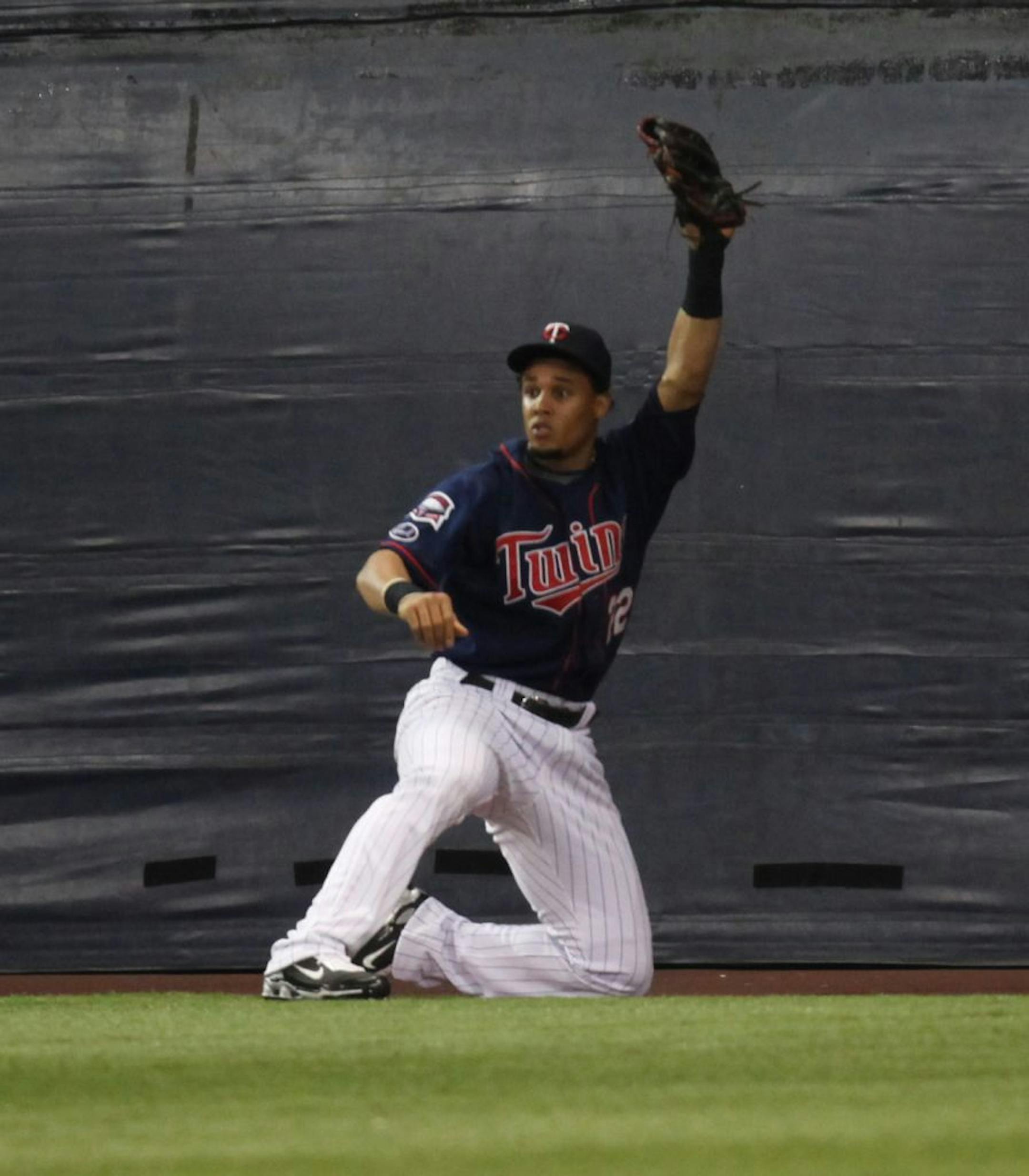 The Minnesota Twins hosted the Cleveland Indians at the Metrodome in Minneapolis Tuesday.] Carlos Gomez signals his catch was good after making catch into the outfield wall in the third inning.