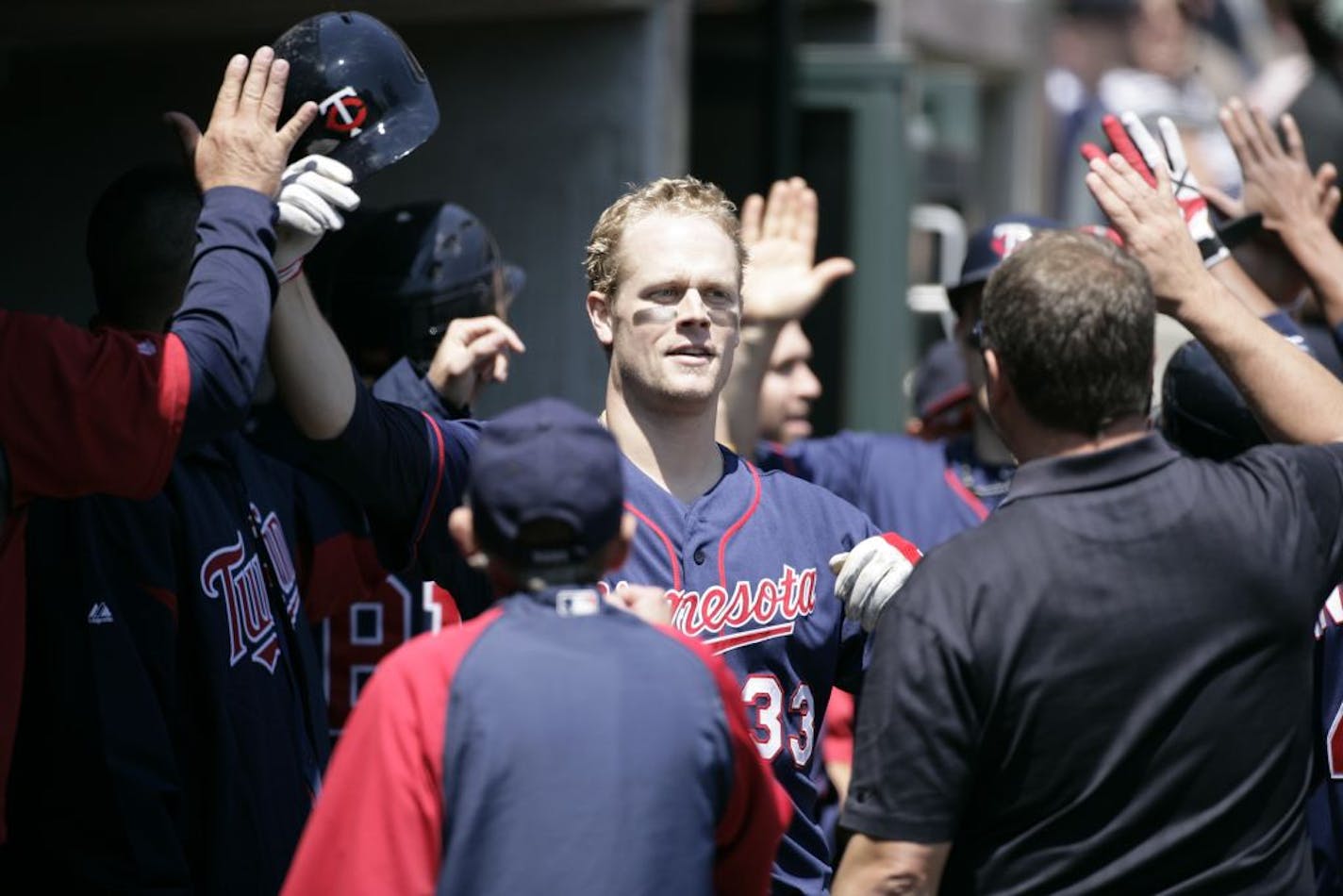 Minnesota Twins' Justin Morneau (33) is congratulated in the dugout after hitting a two-run home run in the third inning of a baseball game against the Detroit Tigers Thursday, May 17, 2012, in Detroit.