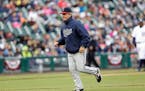 Minnesota Twins pitching coach Neil Allen runs back to the dugout during the fourth inning of a baseball game against the Detroit Tigers, Thursday, Ap