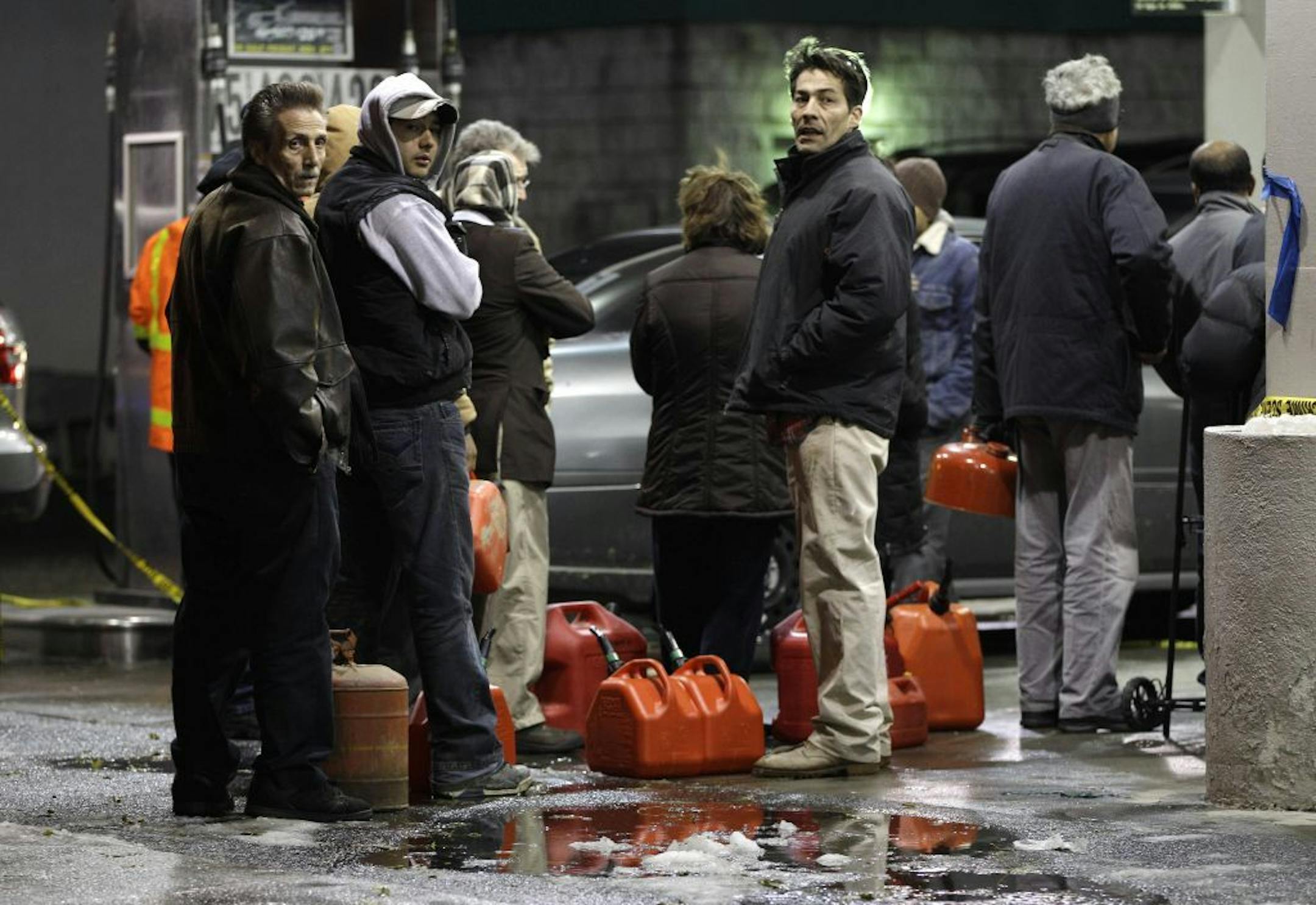 People line up with containers as they wait in line to get gas at a Hess station in the Brooklyn borough of New York where gas is still scarce, Thursday, Nov. 8, 2012. Fuel shortages and distribution delays that led to gas hoarding have prompted New York City and Long Island to initiate an even-odd gas rationing plan which begins Friday at 6 a.m. in New York and 5 a.m. in Long Island.