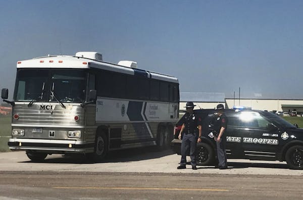 An ICE bus pulls out of a tomato plant in O'Neill, Neb., after an immigration raid at the plant Wednesday, Aug. 8, 2018. A large federal law enforceme