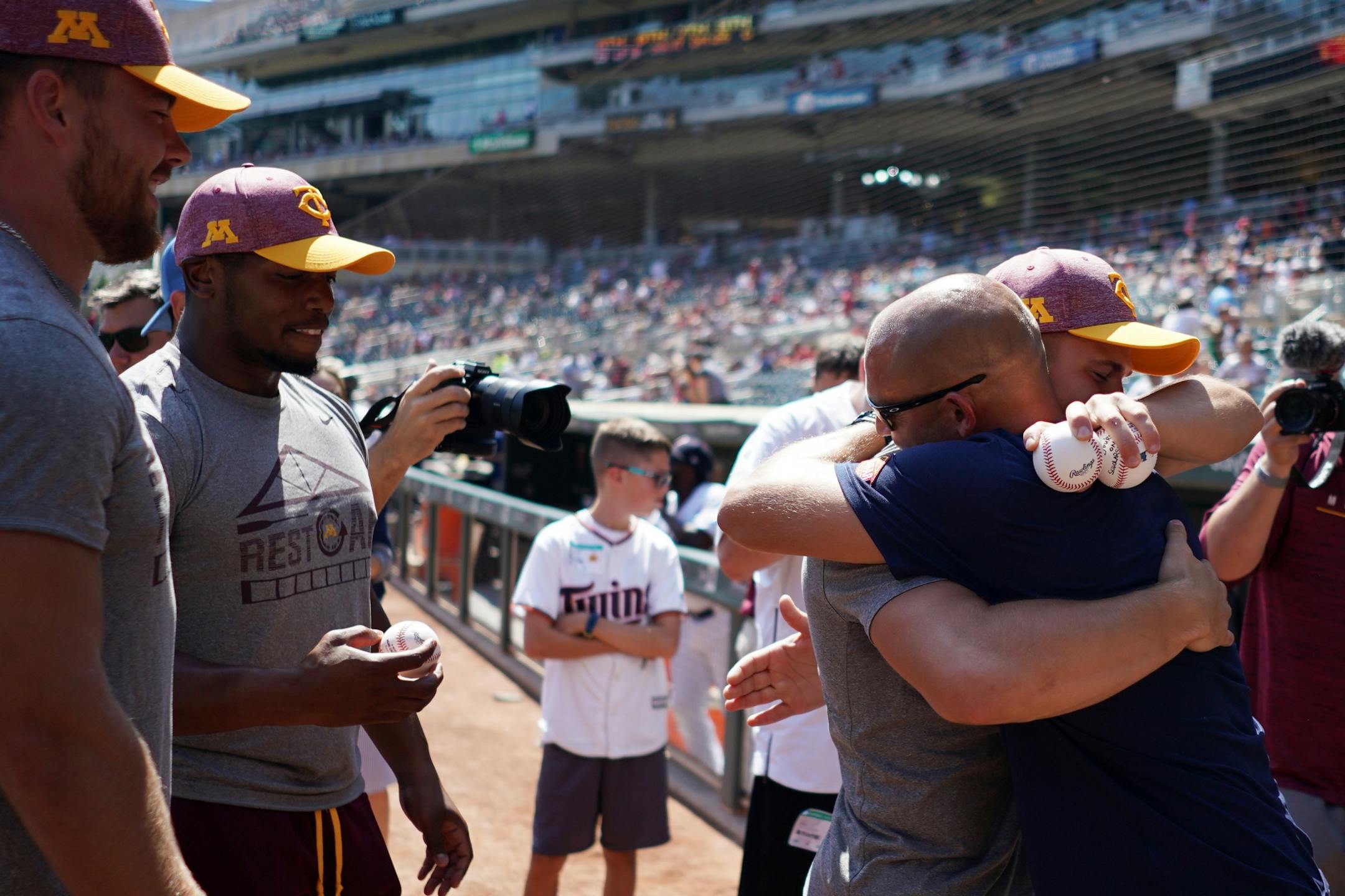 Gophers wide receiver Clay Geary (18) got a hug from head coach P.J. Fleck after he found out he is a scholarship ahead of Wednesday's Twins game.