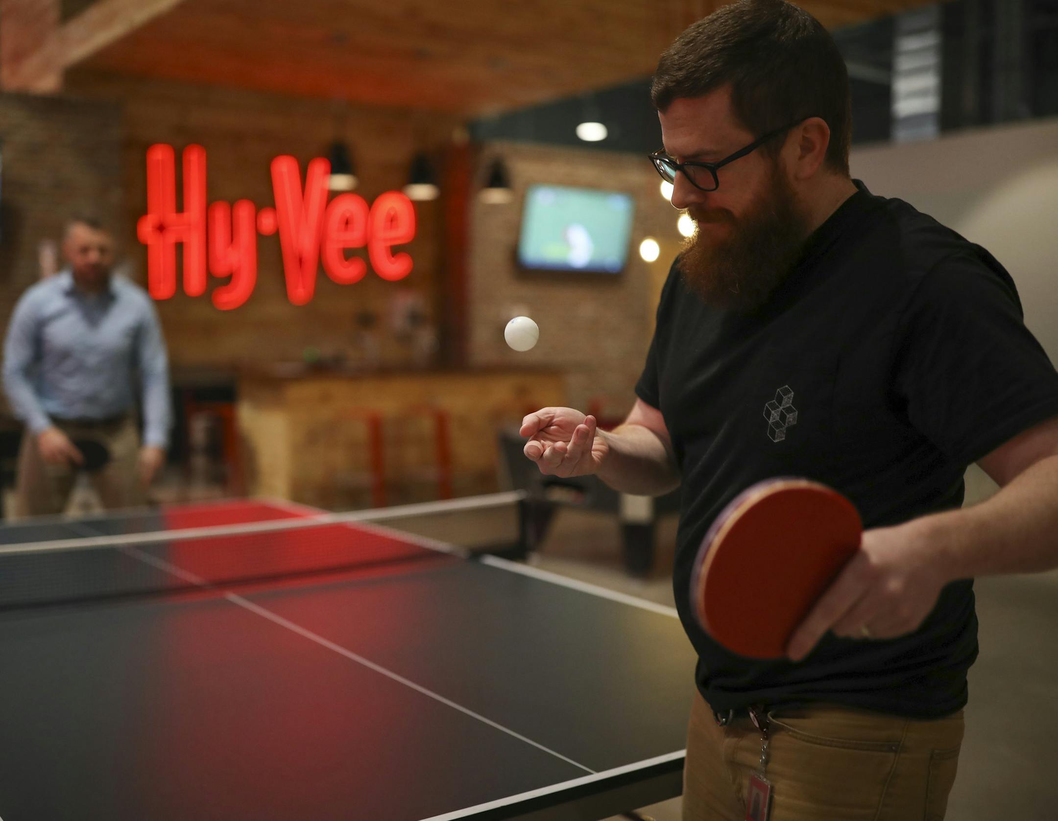 Dan McCurley served to Britt Busch as they played a game of ping pong in the game area after lunch Tuesday afternoon in the HST Center. ] JEFF WHEELER ï jeff.wheeler@startribune.com Des Moines-based grocery giant Hy-Vee, Inc. opened what they dubbed their Helpful Smiles Technology Center in a cavernous warehouse in Grimes, Iowa last year. We take a look at the features of the 104,000-square-foot building that houses the company's information technology workers, in addition to marketing and