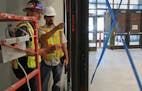 Rick Mickschl, left, and Isaac Stensland inspected work done on an addition at Humboldt High School last week in St. Paul.