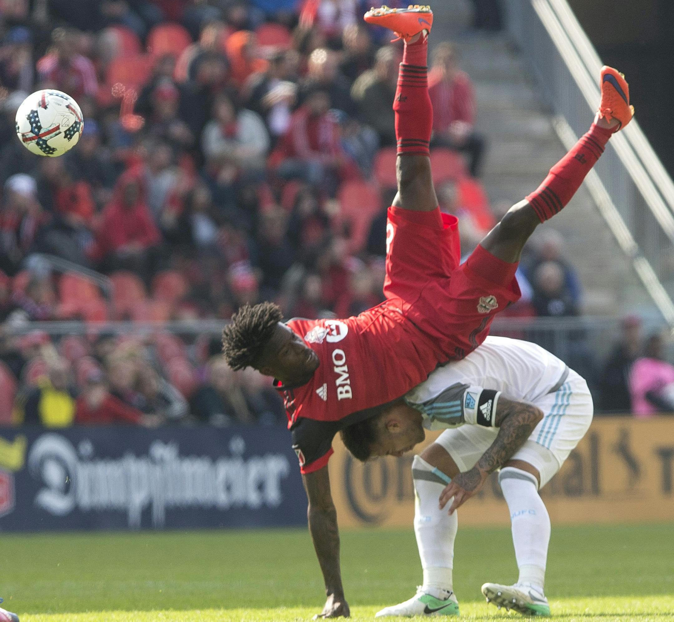 Toronto FC Tosaint Ricketts, top, is upended as he challenges for the ball with Minnesota United FC's Francisco Calvo during the second half of an MLS game in Toronto on Saturday, May 13, 2017. (Chris Young/The Canadian Press via AP)