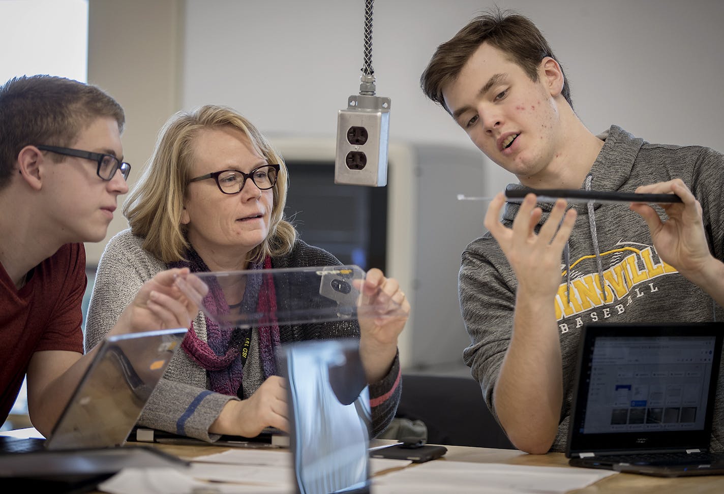 Burnsville High School instructional technology coordinator Rachel Gorton listened to students Josh Holtzleiter, left, and Zach Matthews describe some of their ideas on how to create an iPad protective cover during an engineering class on Wednesday.