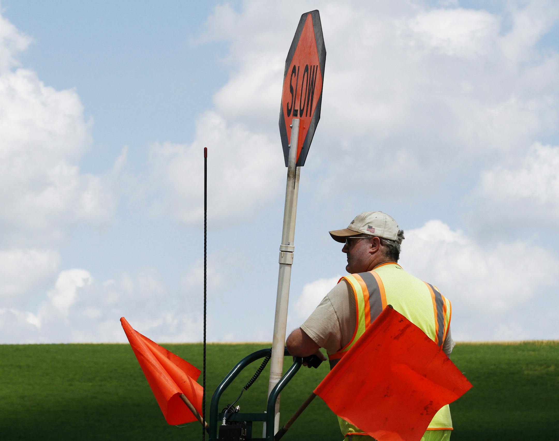 Jim Hackett of Payne and Dolan Inc. monitors traffic moving east through construction on highway 33 in West Bend, Ind. on Thursday, Aug. 1, 2013. (AP Photo/West Bend Daily News, John Ehlke) ORG XMIT: MIN2013080217301648
