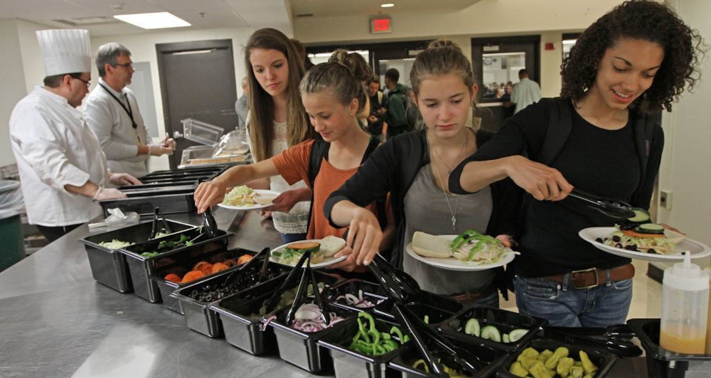 (left to right) Washburn High School Chef Scott Prebish and School Lunch Director Bertrand Weber served custom made sandwiches as students added their own toppings during lunch on 4/26/12. Washburn High School students made their own sandwiches on what students call "real food day" at the high school. The fresh food is part of Weber's changes he's making to lunch, introducing fresh food instead of pre-packaged lunches.