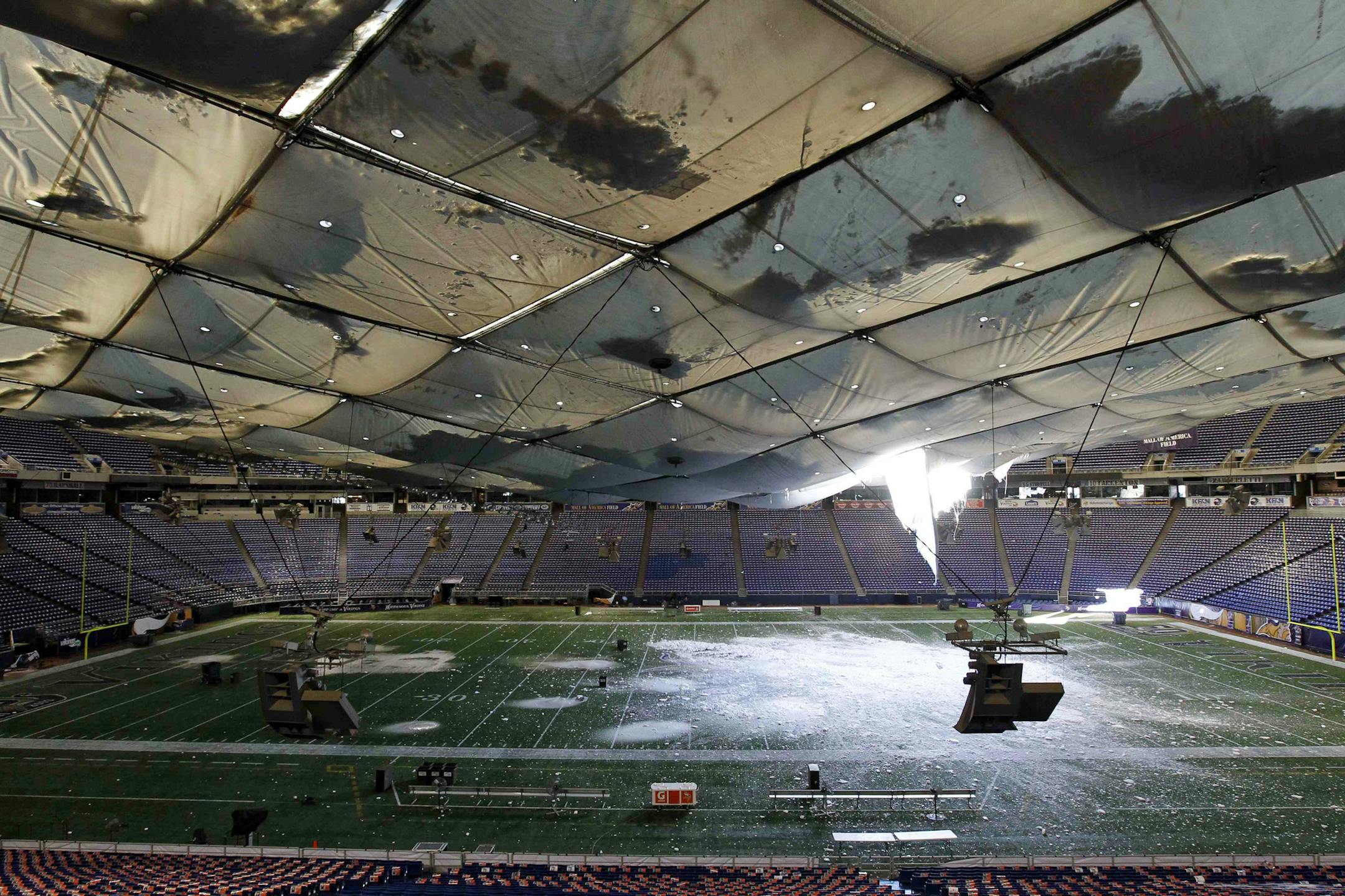 FILE - In this Dec. 12, 2010, file photo, snow falls into the field from a hole in the collapsed roof of the Metrodome in Minneapolis. The landlords of the Metrodome voted unanimously Thursday, Feb. 10, 2011, to replace the snow-damaged roof of the venerable stadium, opting for a more time-consuming fix that could disrupt the Minnesota Vikings preseason schedule. (AP Photo/Ann Heisenfelt, File) ORG XMIT: MIN2013121717125364