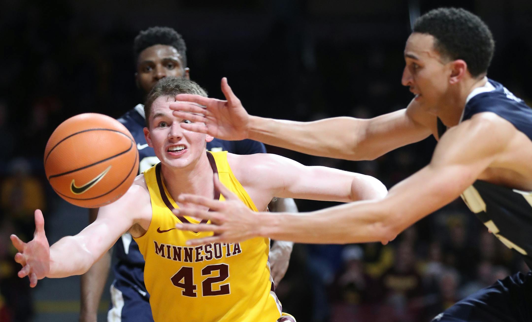 Minnesota's Michael Hurt (42) and Oral Roberts' Javan White, right, chase a loose ball during the second half at Williams Arena in Minneapolis on Thursday, Dec. 21, 2017. The host Golden Gophers won, 77-63. (Leila Navidi/Minneapolis Star Tribune/TNS)