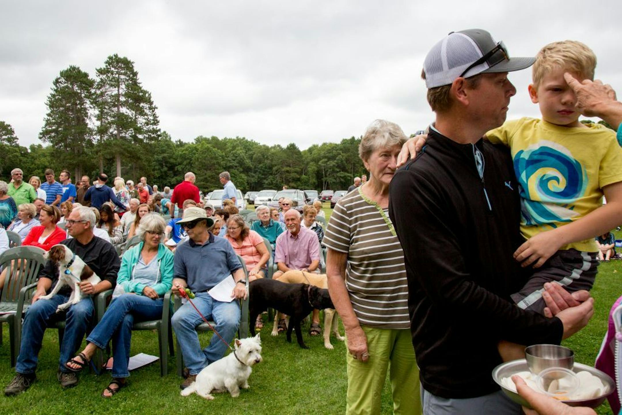 After receiving communion people return to their seats and wait for others during the Crosslake Lutheran Church outdoor service.