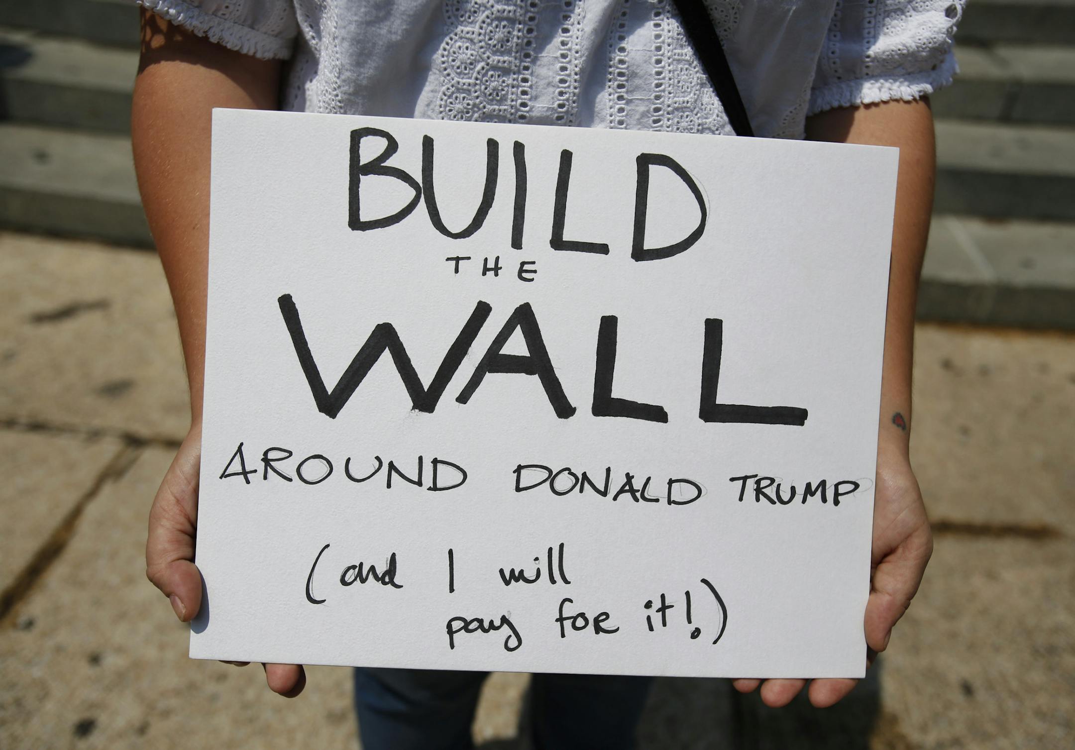 A woman demonstrating against Donald Trump's meeting with the Mexican president carries a sign during a morning protest at the Angel of Independence Monument that drew just a handful of people, in Mexico City, Wednesday, Aug. 31, 2016. Donald Trump is making a quick trip to Mexico on Wednesday, meeting with the president of a nation he derided at the start of his White House campaign as a source of rapists and criminals coming to the U.S.(AP Photo/Rebecca Blackwell)