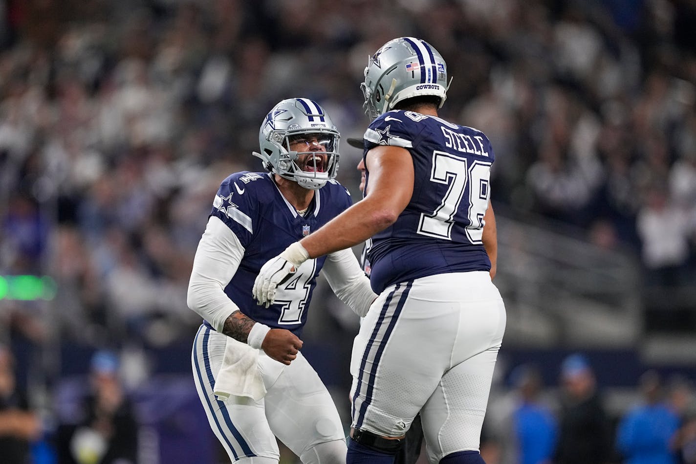 Cowboys quarterback Dak Prescott celebrates with offensive tackle Terence Steele after throwing a touchdown pass against the Lions during the second half Saturday