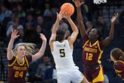 The Gophers' Mallory Heyer (24) and Ajok Madol (12) defended against Michigan's Laila Phelia during the Big Ten tournament at Target Center.