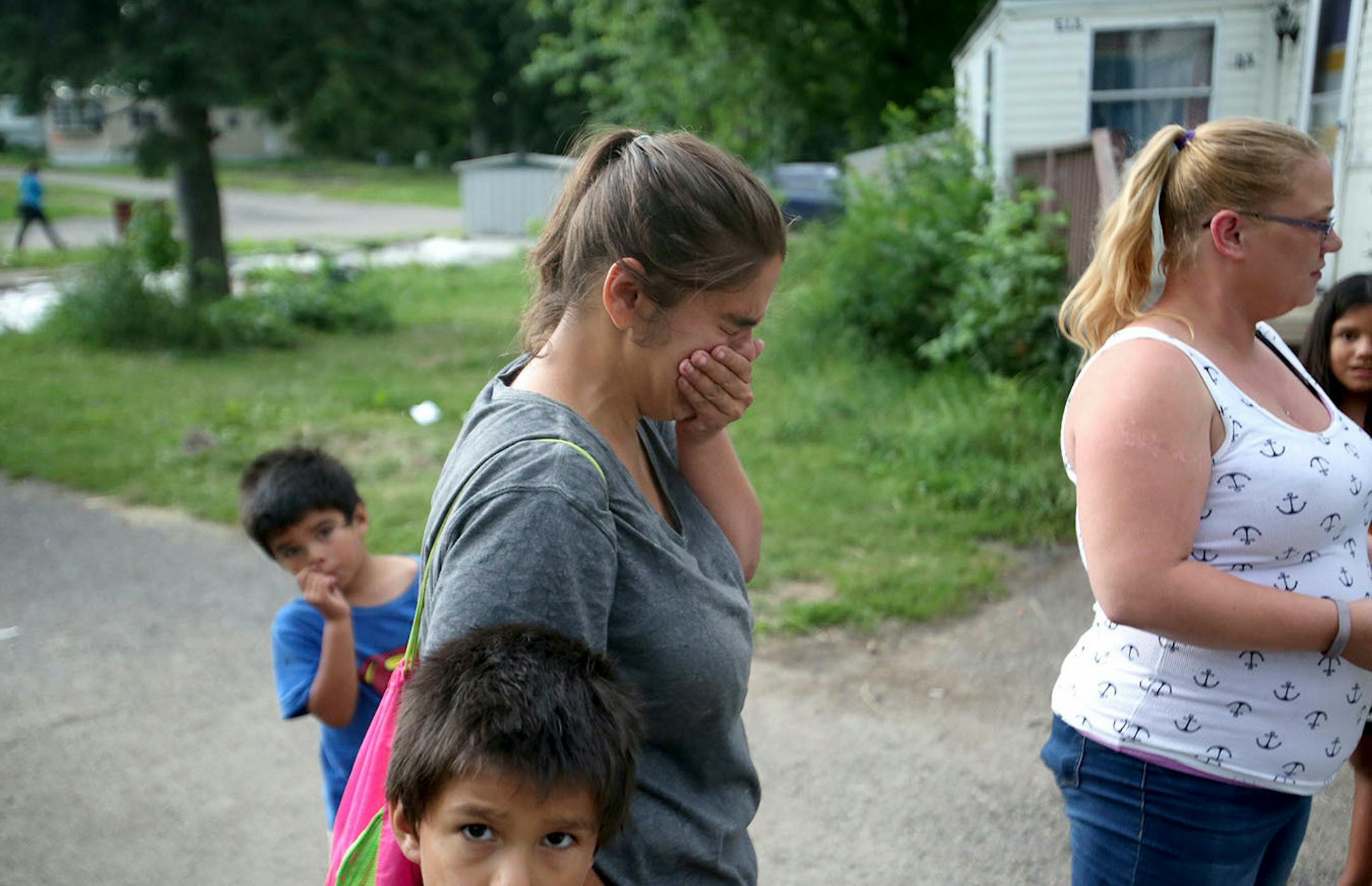 Mindy Lopez, center, Lowry Grove mobile home resident, breaks down in tears as she moves the last of her family's things to her best friend's waiting vehicle Friday, June 30, 2017, in St. Anthony, MN. Lowry Grove closed it's gate and all residents had to be gone by 12 midnight the following day, the space slated to be redeveloped into multiple-family housing.