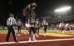 Teammates, including Gophers wide receiver Tyler Johnson (6), celebrated with running back Mohamed Ibrahim (24) after he scored a second half touchdow