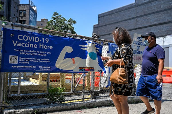 A pedestrian pointed to a sign advertising COVID-19 vaccines in New York, July 23, 2021. 