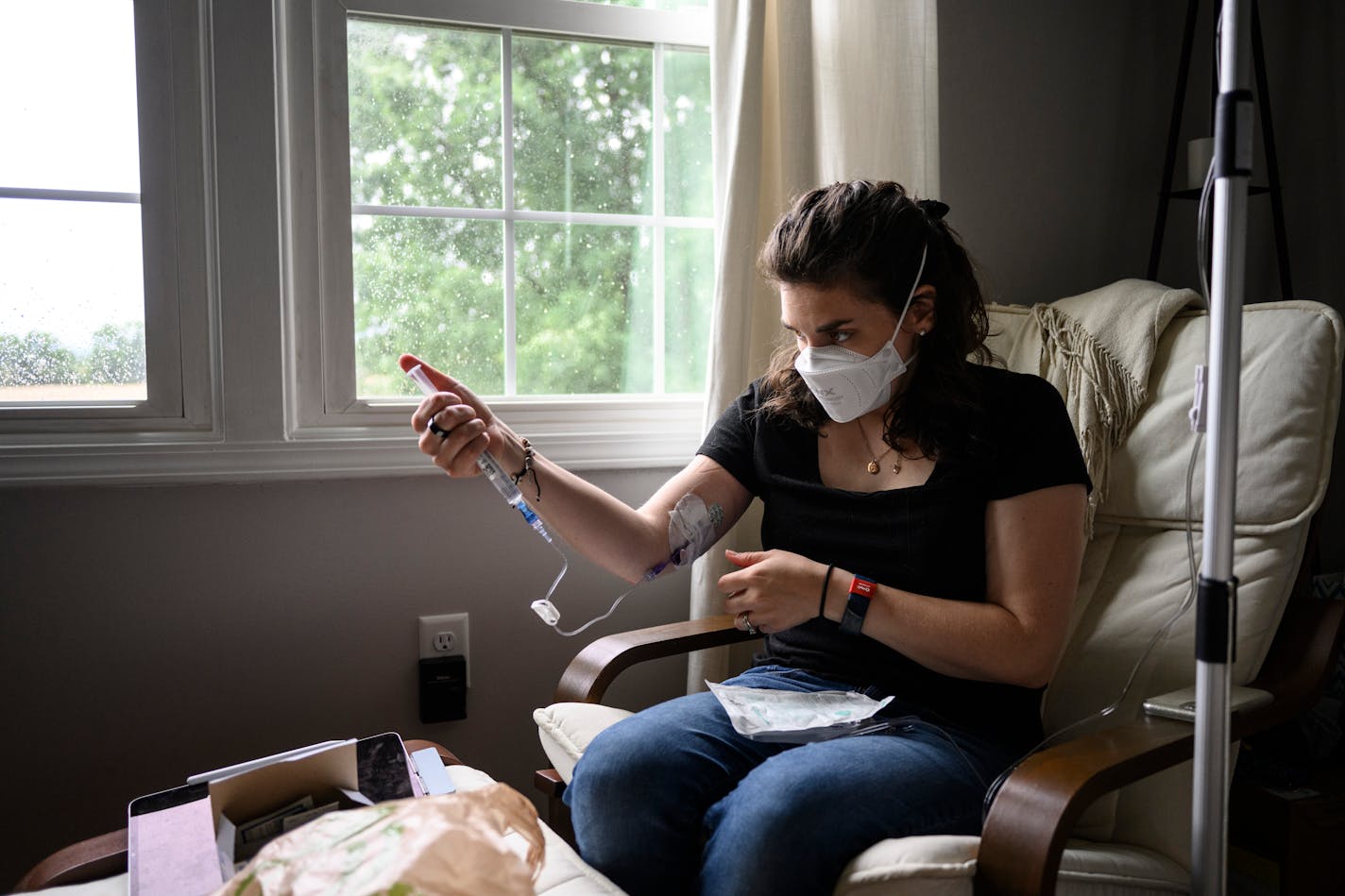 Mallory Stanislawczyk, a former nurse practitioner, administers a saline infusion at home in Walkersville, Md., in May. Long covid has made it difficult for her to stand up without fainting. MUST CREDIT: Photo for The Washington Post by Matt Roth.