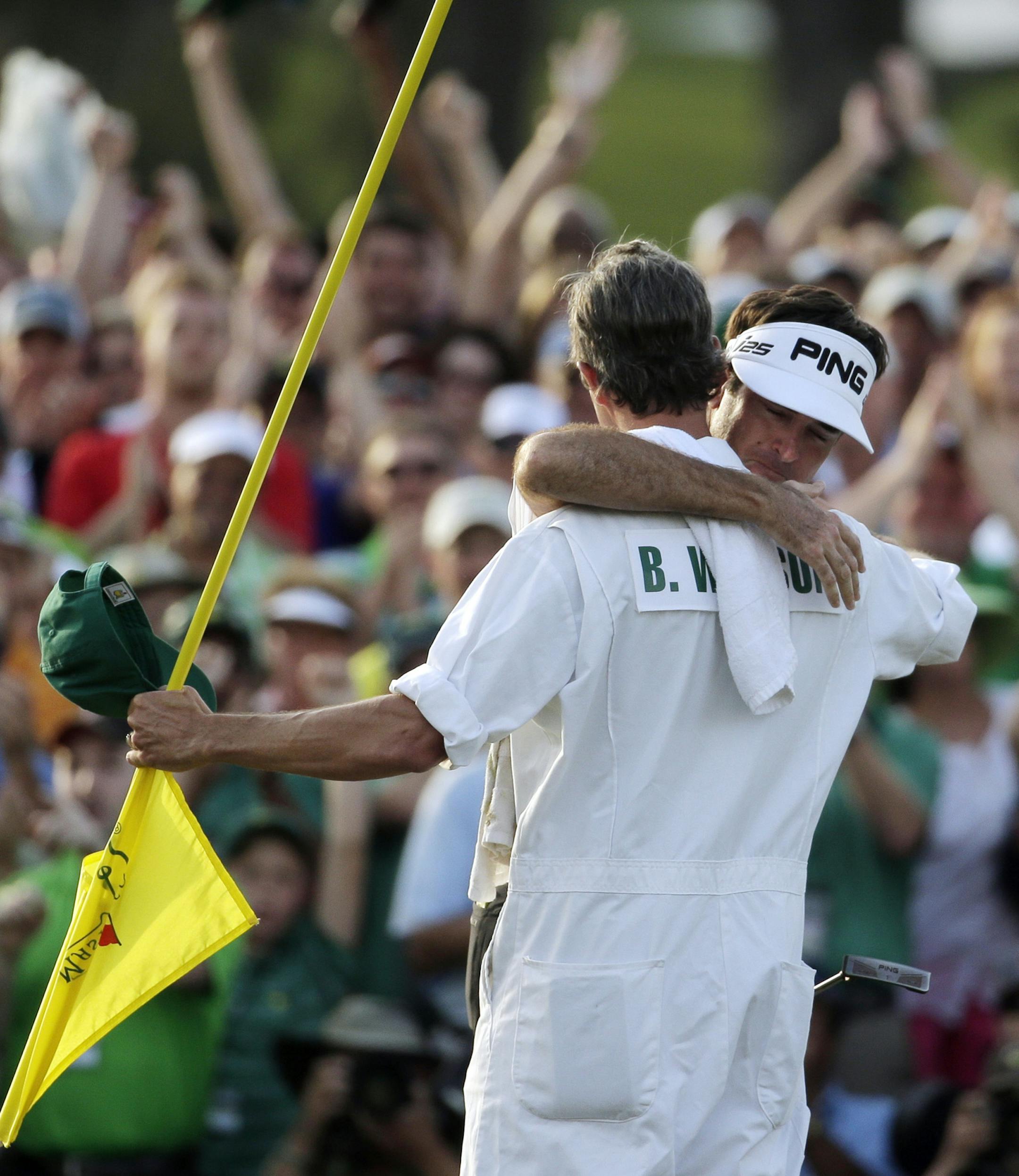 Caddie Ted Scott hugs Bubba Watson after winning the Masters golf tournament Sunday, April 13, 2014, in Augusta, Ga.(AP Photo/Chris Carlson)
