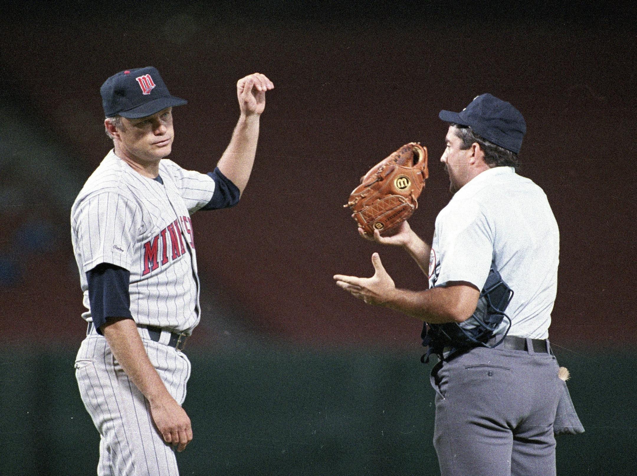 FILE - In this Aug. 3, 1987, file photo, Minnesota Twins pitcher Joe Niekro tosses his glove to home plate umpire Tim Tscida after the umpire stopped the baseball game between the Twins and Angels in Anaheim, Calif. Niekro's lame attempt in 1987 to casually toss away a piece of emery board from his back pocket while standing on the pitcher's mound in front of 33,983 fans got him ejected and suspended for 10 days. He claimed he used the emery board to file his nails. Blurring the line between leg