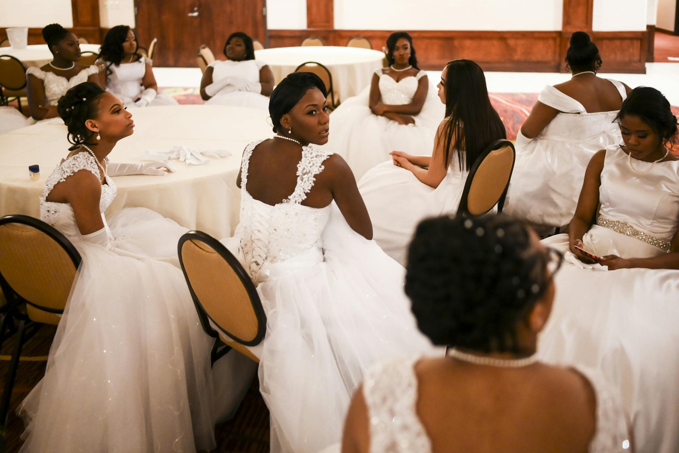 The debutantes waited patiently for the start of Saturday night's winter cotillion. In the middle is Di'Vada-Ka'Mia Wilson, a senior at Eden Prairie High School .