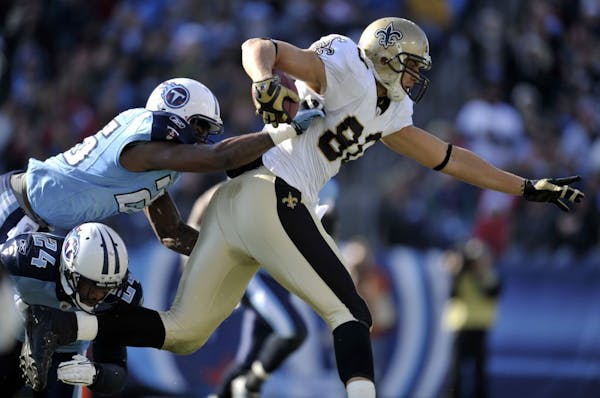 New Orleans Saints tight end Jimmy Graham (80) carries the ball against Tennessee Titans defenders Anthony Smith (25) and Chris Hope (24) in the secon